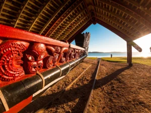 carved Māori wharenui interior with traditional red patterns