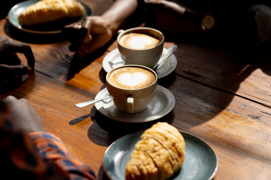 coffee cups and pastries on wooden table
