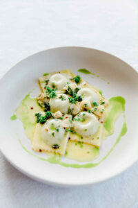 Creamy pasta dish garnished with herbs in a white bowl